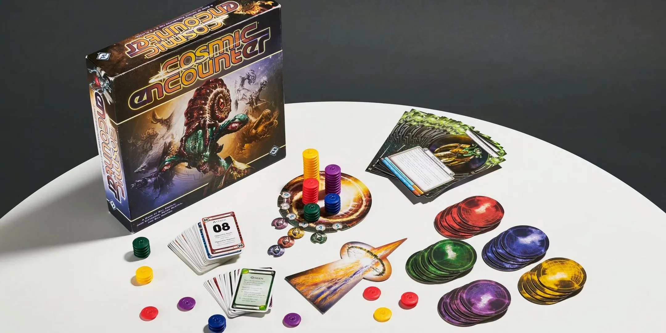 Các quân cờ và hộp game Cosmic Encounter được bày ra.