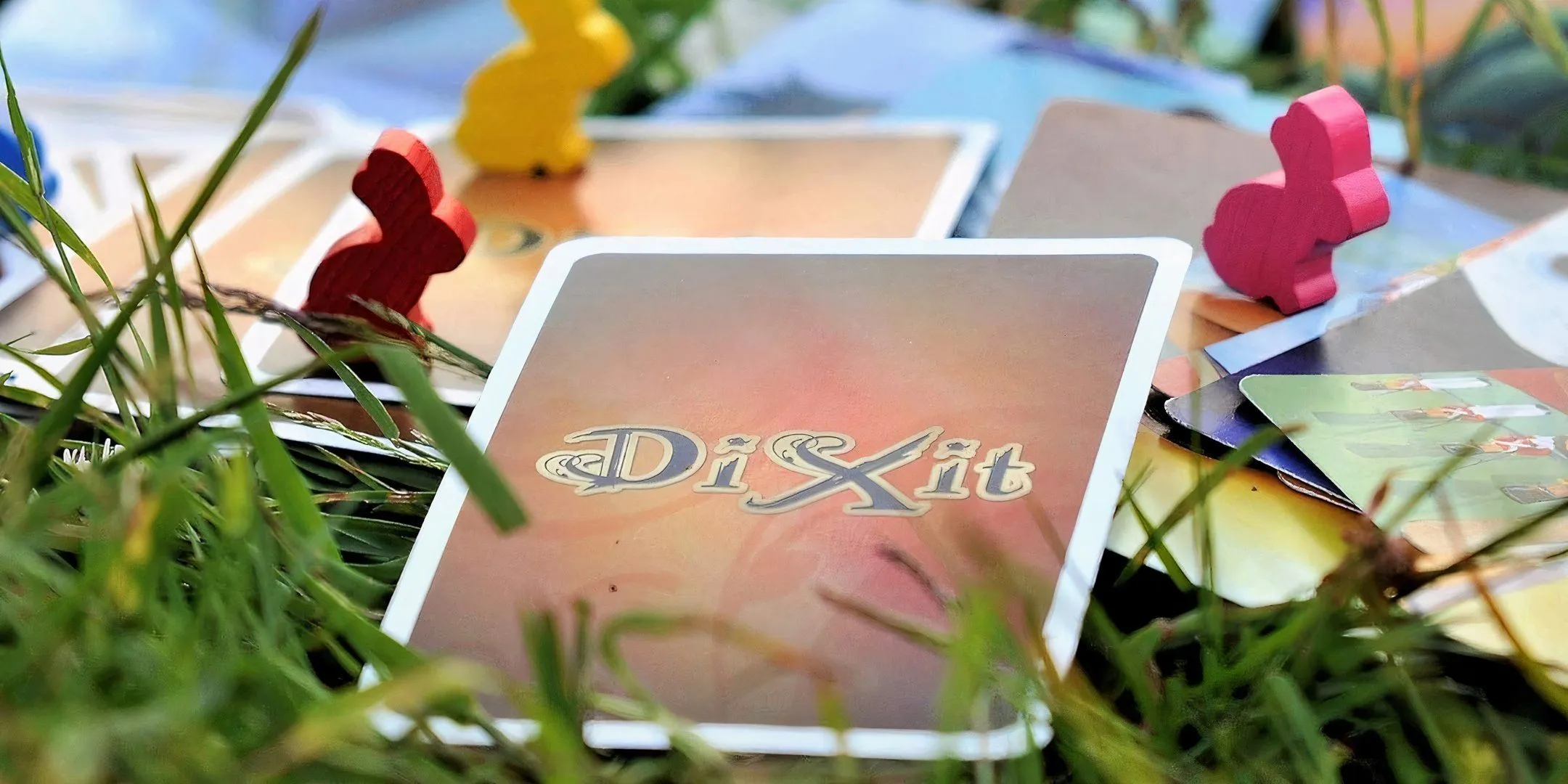 Hộp game Dixit với các lá bài nghệ thuật trừu tượng, thể hiện tính chất kể chuyện và liên tưởng tự do của game.