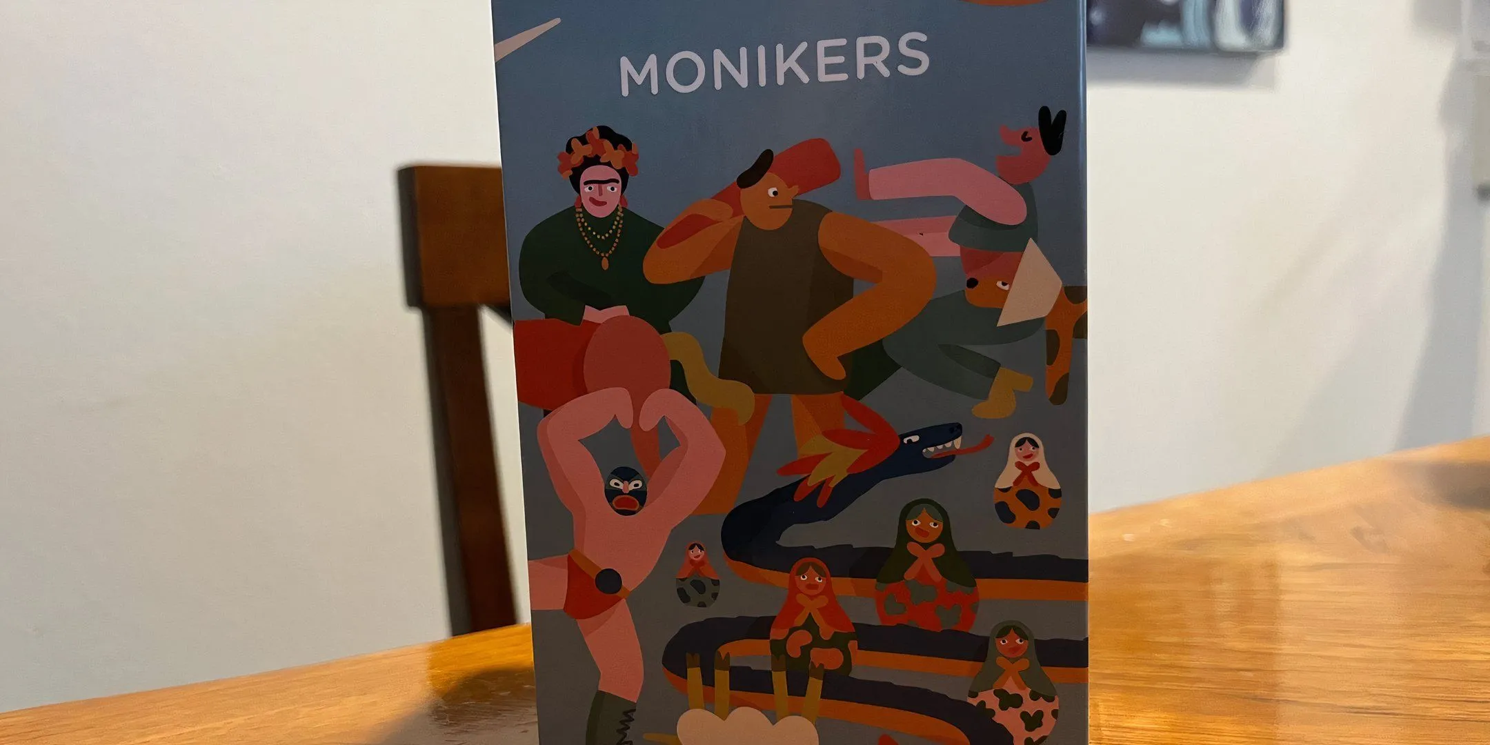 Hộp game Monikers màu sắc tươi sáng, gợi ý về một trò chơi tiệc tùng vui nhộn với các vòng đoán từ.